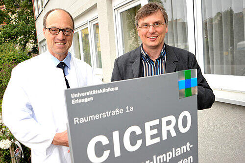 Prof. Heinrich Iro (li.) und Prof. Ulrich Hoppe vor dem neuen CICERO-Zentrum für Cochlear-Implantate.