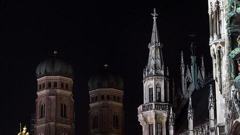 Die Bildkombo zeigt die Frauenkirche und das Rathaus in München beleuchtet und unbeleuchtet. Foto: Matthias Balk/Archiv