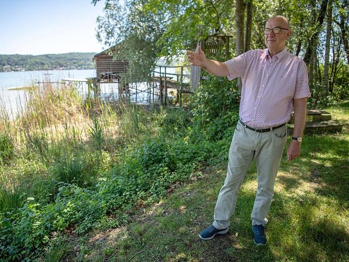 Stephan Seiz, Rechtsanwalt, steht auf einem Grünstreifen direkt am Ammersee und zeigt auf die "mückenbelasteten" Orte. Foto: Lino Mirgeler