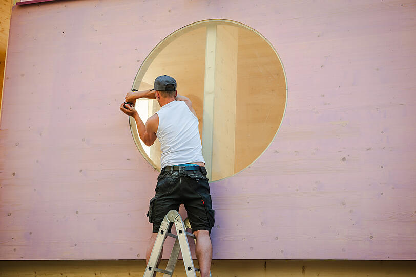 Letzte Arbeiten am "Zuhaus": Ein rundes Fenster wird noch montiert.