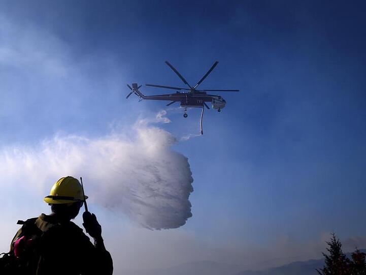 Ein Hubschrauber ist bei einem Waldbrand im Einsatz.