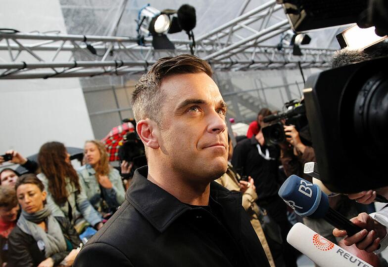Weltstar im Fan-Gewusel: Robbie Williams verteilte Autogramme vor dem Mathäser-Kino.