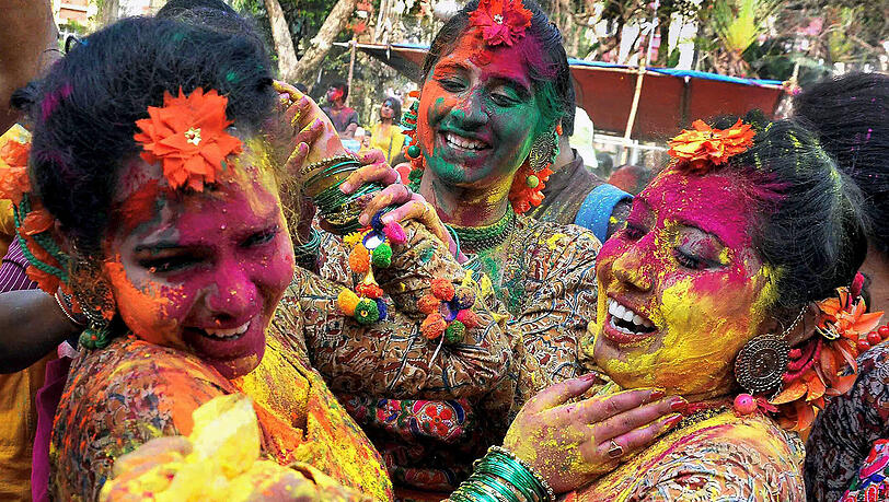 Frauen bestreichen sich beim Holi Festival gegenseitig mit dem Farbpulver «Gulal». Frauen bestreichen sich beim Holi Festival gegenseitig mit dem Farbpulver «Gulal».