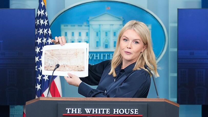 Projektgrafiken zeigen goldene Kronleuchter über einem Saal im hell gehaltenen Look.