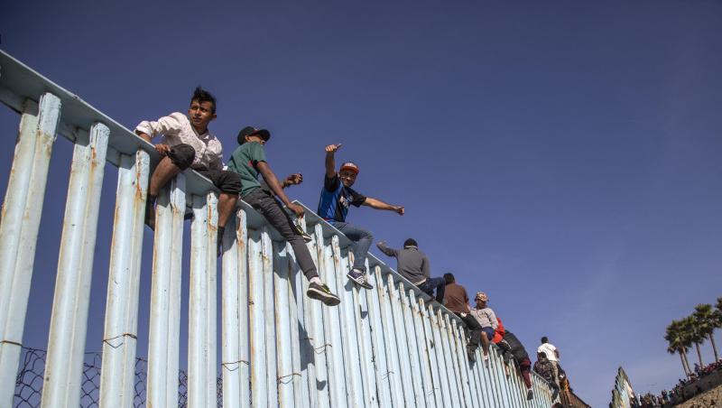 Migranten aus Mittelamerika sitzen in Tijuana auf dem Grenzzaun zwischen Mexiko und den USA. Migranten aus Mittelamerika sitzen in Tijuana auf dem Grenzzaun zwischen Mexiko und den USA.