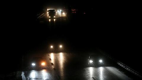 Autos fahren am frühen Morgen auf der Bundesstraße 16 im Schneetreiben.