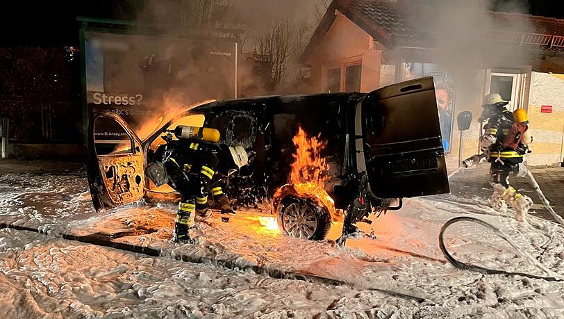 Ein Teppich aus Löschschaum ist um das brennende Auto ausgebreitet.
