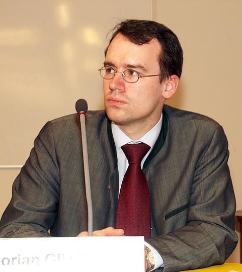 Staatsanwalt Florian Gliwitzky (38) wird die vierseitige Anklageschrift gegen den mutmaßlichen Mörder stehend im Münchner Schwurgerichtssaal 101 verlesen. Er hatte auch die Ermittlungen gegen den Tatverdächtigen geführt. Gliwitzky wirft dem Angeklagten vor, dass er aus Heimtücke und Habgier seine beiden Nichten ermordet hat. Nach dem Gericht ist der Staatsanwalt mit seiner Befragung an der Reihe.