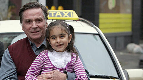 Der Schauspieler Elmar Wepper steht mit der jungen Mercan Türkoglu am Dienstag (02.11.2010) in Nürnberg (Mittelfranken) am Rande der Dreharbeiten zum Kinofilm "Dreiviertelmond" an einem Taxi.