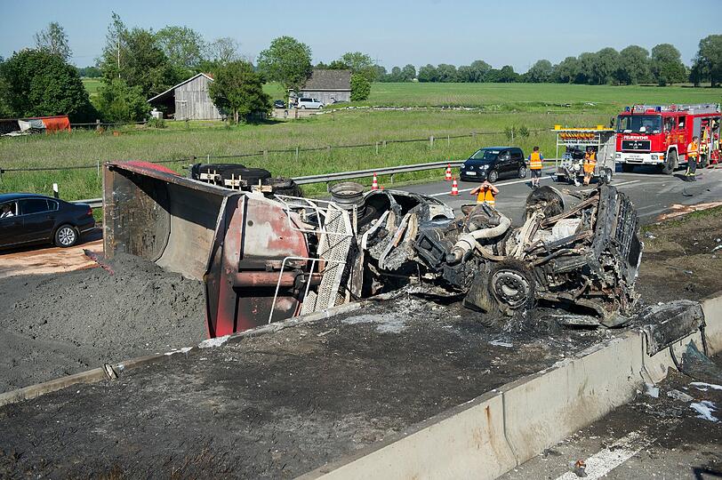 Rettungskräfte auf der Autobahn A8 bei Sulzemoos (Oberbayern) an einem ausgebrannten Lastwagen. Zwei weitere Autos sind in den Auflieger des Lastwagens gefahren. Bei dem Unfall kam mindestens eine Person ums Leben.