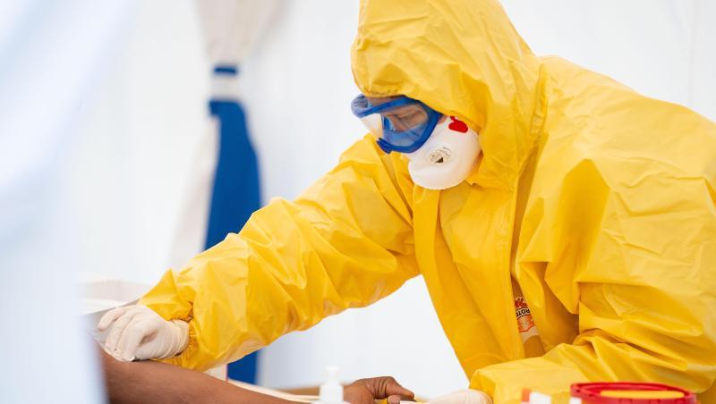 Eine Rettungssanitäterin entnimmt in einem Zelt einem Patienten Blut. Eine Rettungssanitäterin entnimmt in einem Zelt einem Patienten Blut.