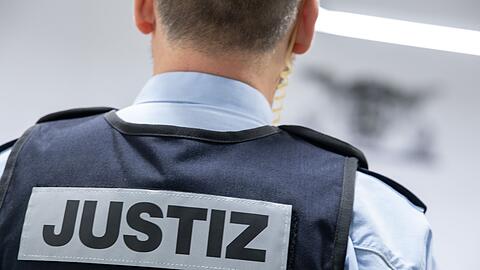 Ein Justizbeamter steht in einem Gerichtssaal.