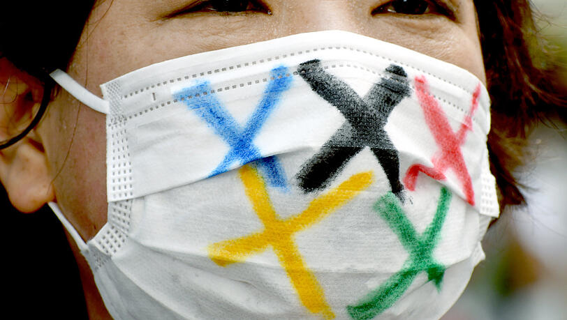 Vor dem Stadion in Tokio protestieren einige Japaner aus Angst vor der Corona-Pandemie gegen die Ausrichtung der Spiele. Vor dem Stadion in Tokio protestieren einige Japaner aus Angst vor der Corona-Pandemie gegen die Ausrichtung der Spiele.