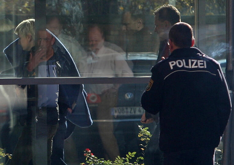 Beate Z. (links) wird am Mittwoch, den 09.11.11 verdeckt von einer blauen Decke in Zwickau nach einem Termin beim Haftrichter von Polizeibeamten aus einem Gebäude der Staatsanwaltschaft geführt.