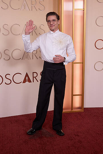 Pedro Pascal: Der Look bricht bewusst mit der klassischen Oscar-Silhouette. Statt des traditionellen Smokings steht hier das Hemd im Fokus, ergänzt durch ein auffälliges Feder-Detail. Das wirkt modern, fast avantgardistisch – und zeigt, dass auch auf dem Oscar-Red-Carpet Platz für modische Experimente ist. Pedro Pascal: Der Look bricht bewusst mit der klassischen Oscar-Silhouette. Statt des traditionellen Smokings steht hier das Hemd im Fokus, ergänzt durch ein auffälliges Feder-Detail. Das wirkt modern, fast avantgardistisch – und zeigt, dass auch auf dem Oscar-Red-Carpet Platz für modische Experimente ist.