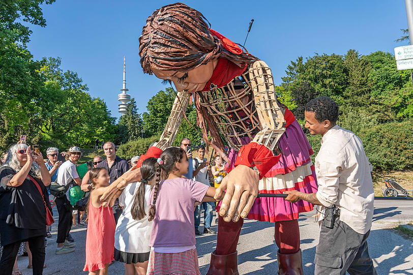 Eröffnet wurde das diesjährige Sommertollwood mit "Little Amal", einer 3,5 Meter großen Puppe, die ein zehnjähriges Flüchtlingsmädchen verkörpert. Eröffnet wurde das diesjährige Sommertollwood mit "Little Amal", einer 3,5 Meter großen Puppe, die ein zehnjähriges Flüchtlingsmädchen verkörpert.