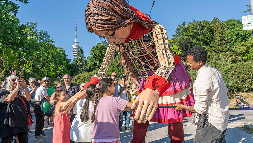 Eröffnet wurde das diesjährige Sommertollwood mit "Little Amal", einer 3,5 Meter großen Puppe, die ein zehnjähriges Flüchtlingsmädchen verkörpert. Eröffnet wurde das diesjährige Sommertollwood mit "Little Amal", einer 3,5 Meter großen Puppe, die ein zehnjähriges Flüchtlingsmädchen verkörpert.