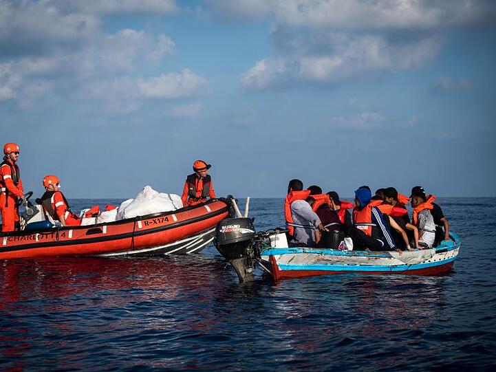 Besatzungsmitglieder des Rettungsschiff "Alan Kurdi" kommen Migranten in eine Holzboot auf dem offenen Meer zur hilfe. Foto: Nick Jaussi/Archivbild