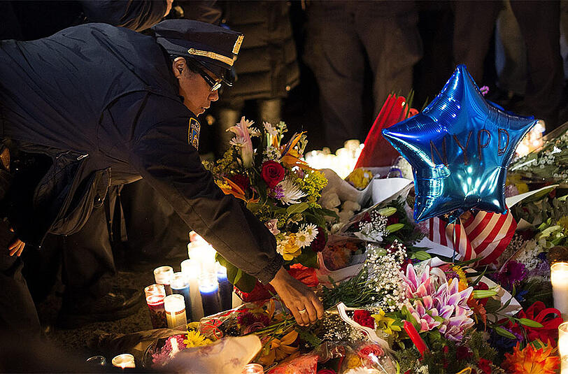 Ein Polizist legt Blumen an die Gedenkstätte.