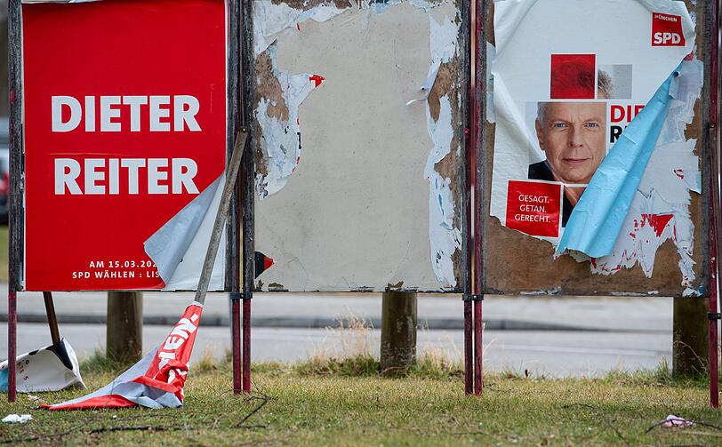 Auch ein zerstörtes Wahlplakat der SPD steht an einem Straßenrand in München.