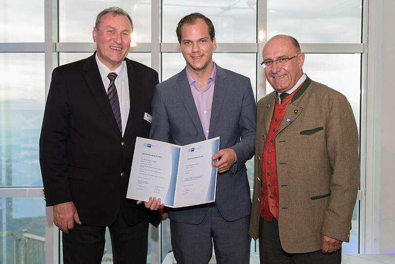 Bei der Feierstunde der IHK für München und Oberbayern: IHK-Vizepräsident Gerhard Lutz (r.) und Josef Amann, Bereichsleiter Berufsbildung der IHK, übergeben die Urkunde an Oberbayerns Top-Azubi, Martin Johannes Petersen.