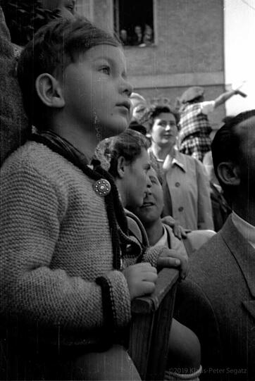 Total fasziniert und hochkonzentriert verfolgt dieser kleine Münchner Bub mit Trachtenjanker den Einzug der Trachtler zum Oktoberfest im Jahr 1950.