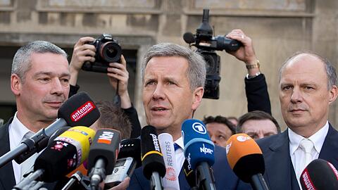 Ex-Bundespräsident Christian Wulff nach der Urteilsverkündung das Landgericht. Neben ihm stehen die Anwälte Michael Nagel (r) und Bernd Müssig.