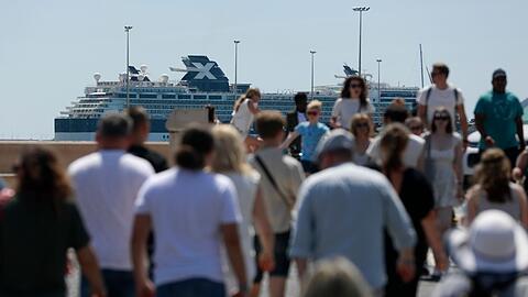 Touristen eines Kreuzfahrtschiffes spazieren auf der Promenade von Palma de Mallorca.