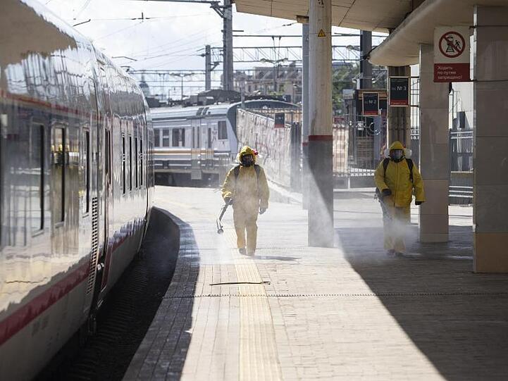 Staatliche Mitarbeiter in Schutzkleidung desinfizieren den Kiewer Bahnhof in Moskau.