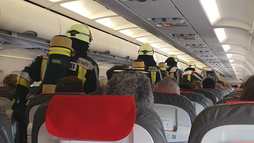 Sechs Feuerwehrmänner stürmen in das Flugzeug nach vorne zur Bordküche.