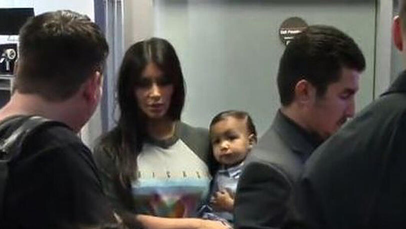 Kim Kardashian im lässigen Pullover mit Töchterchen North auf dem Arm Kim Kardashian im lässigen Pullover mit Töchterchen North auf dem Arm