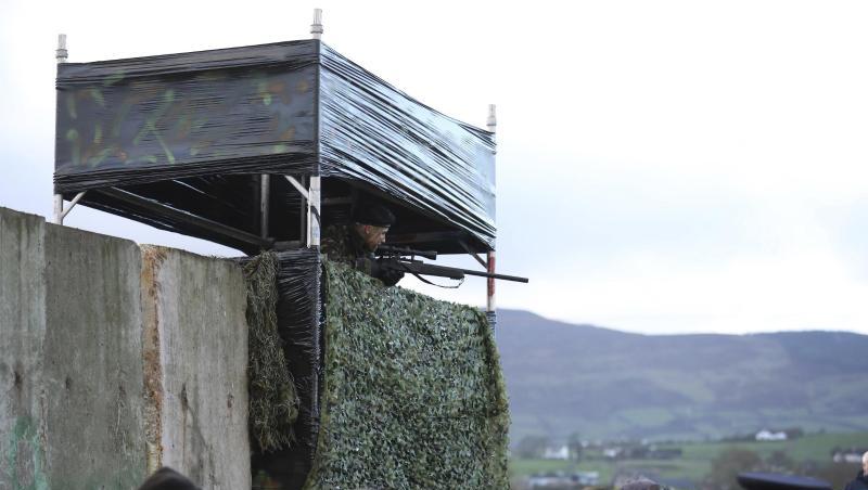 Ein als Soldat verkleideter Demonstrant steht auf einer Wachturm-Attrappe. Ein als Soldat verkleideter Demonstrant steht auf einer Wachturm-Attrappe.
