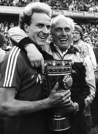 Der strahlende Bayern-Trainer Udo Lattek (r.) und sein Stürmer-Star Karl-Heinz Rummenigge halten am 31.05.1984 im Frankfurter Waldstadion den DFB-Pokal fest in ihren Händen.