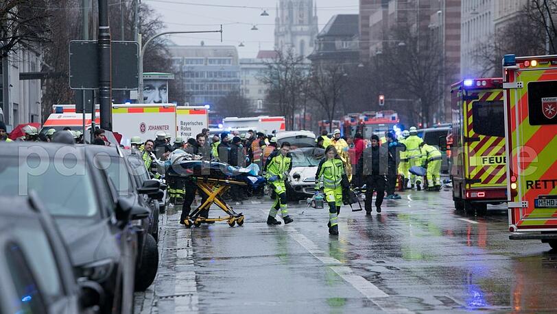 Minuten nach der Todesfahrt in der Münchner Seidlstraße mit zwei Toten und mindestens 37 Verletzten: Retter bergen noch Opfer, Polizisten untersuchen den Mini Cooper, mit dem der mutmaßliche Täter in die Menschenmenge gerast ist.
