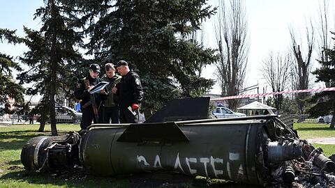 Ukrainische Soldaten während Ermittlungsarbeiten neben einem Fragment einer Tochka-U-Rakete mit der russischen Aufschrift "Für Kinder" nahe des Bahnhofs in Kramatorsk.