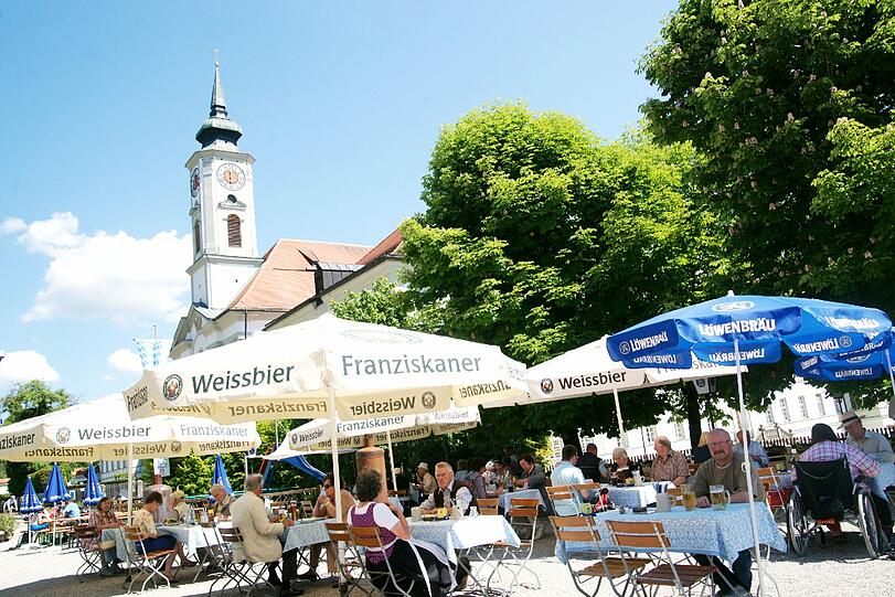 Im Schatten von Schirmen, Bäumen und der barocken Kirche: Die Gäste des Klosterbräustüberls in Schäftlarn schätzen an diesem Biergarten die familiäre, unaufgeregte Atmosphäre.