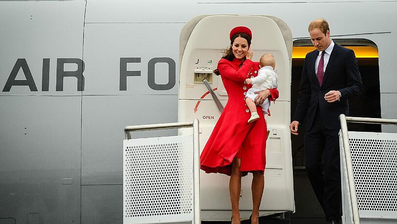 Trotz Wind und Regen strahlt das royale Paar, als es mit Baby George das Flugzeug am Flughafen in Wellington verlässt. Trotz Wind und Regen strahlt das royale Paar, als es mit Baby George das Flugzeug am Flughafen in Wellington verlässt.