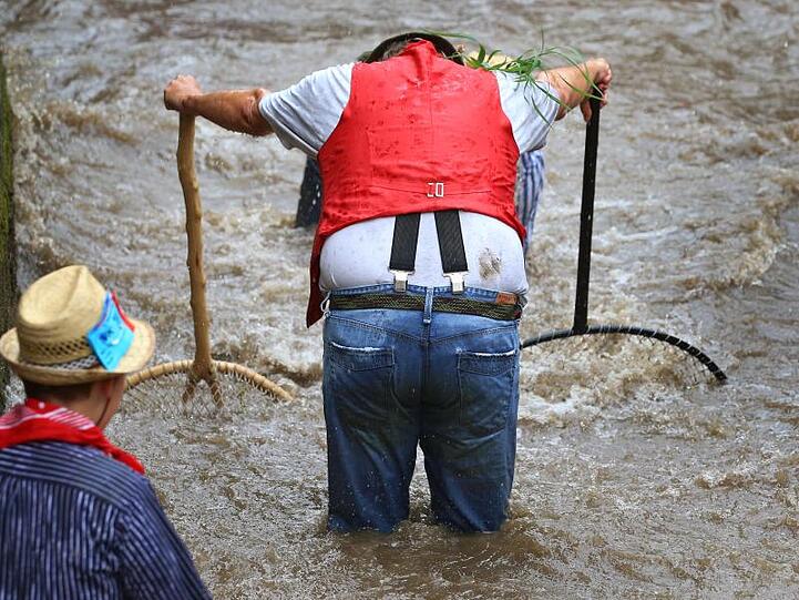 Ein Teilnehmer des Fischertages steht während des Ausfischens mit zwei Keschern im Stadtbach. Foto: Karl-Josef Hildenbrand/Archivbild