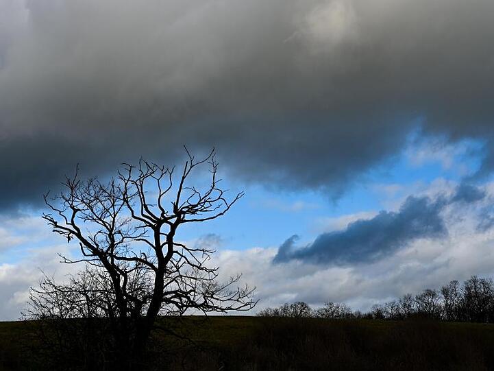 Dunkle Wolken ziehen über eine Landschaft. Foto: Patrick Pleul/dpa-Zentralbild/ZB/Symbolbild