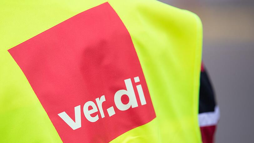 Ein Beschäftigter trägt bei einem Warnstreik eine Warnweste von Verdi.