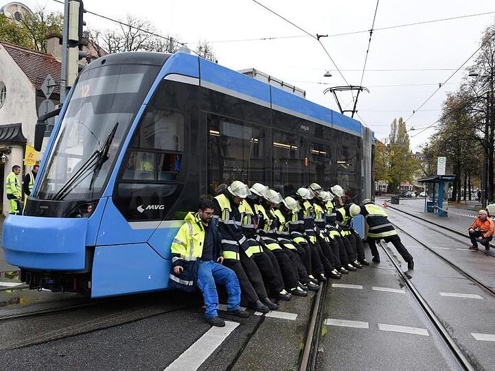 Feuerwehrleute befördern eine aus den Gleisen gesprungene Straßenbahn zurück in die Spur. Foto: Saurer/Berufsfeuerwehr München/dpa