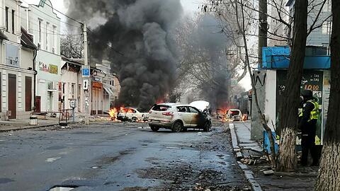 Autos brennen nach einem russischen Raketenangriff auf das Stadtzentrum von Cherson.