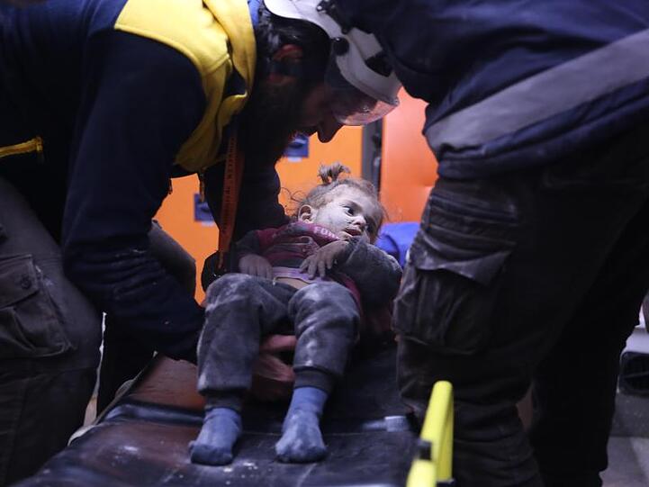 Rettungskräfte versorgen nach einem Luftangriff ein verwundetes syrisches Mädchen.