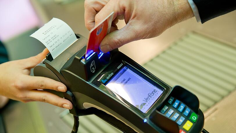 Ein Kunde zahlt in einem Supermarkt mit einer EC-Karte an der Kasse.