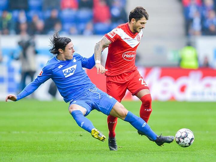 Hoffenheims Nico Schulz (l) versucht vor Düsseldorfs Matthias Zimmermann an den Ball zu kommen.