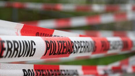 Ein Einsatzort der Polizei ist mit Flatterband abgesperrt.