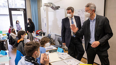 Markus Söder (links, CSU) Ministerpräsident von Bayern, und Michael Piazolo, (Freie Wähler) Staatsminister für Unterricht und Kultus, verabschieden sich von Kindern aus der Ukraine, die sie in einer Willkommensklasse des Gymnasium Trudering besucht haben.