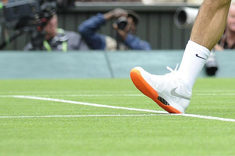 Roger Federers Schuhsohlen sind orange - das ist in Wimbledon nicht gestattet.