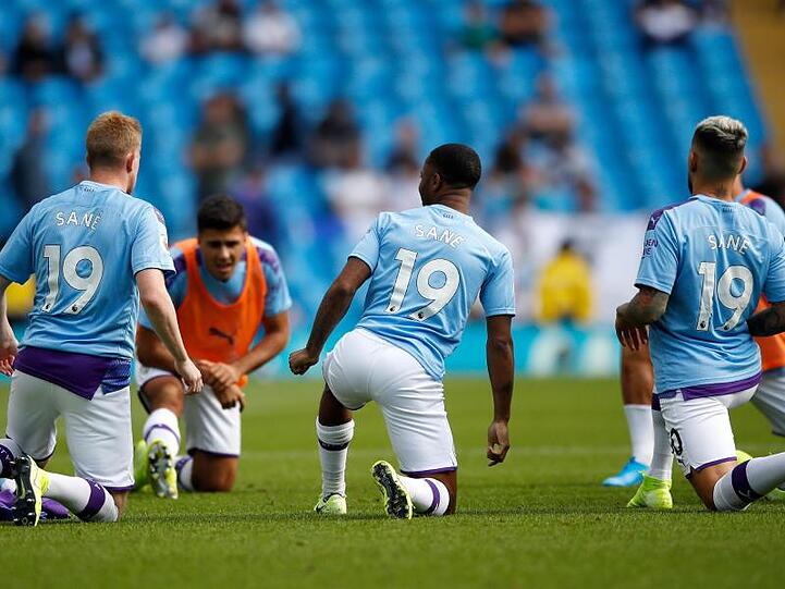 Kevin de Bruyne (l-r), Raheem Sterling und Nicolas Otamendi tragen das Trikot des verletzten Leroy Sané.