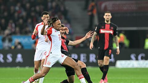 Münchens Sacha Boey (l) und Leverkusens Josip Stanisic kämpfen um den Ball.